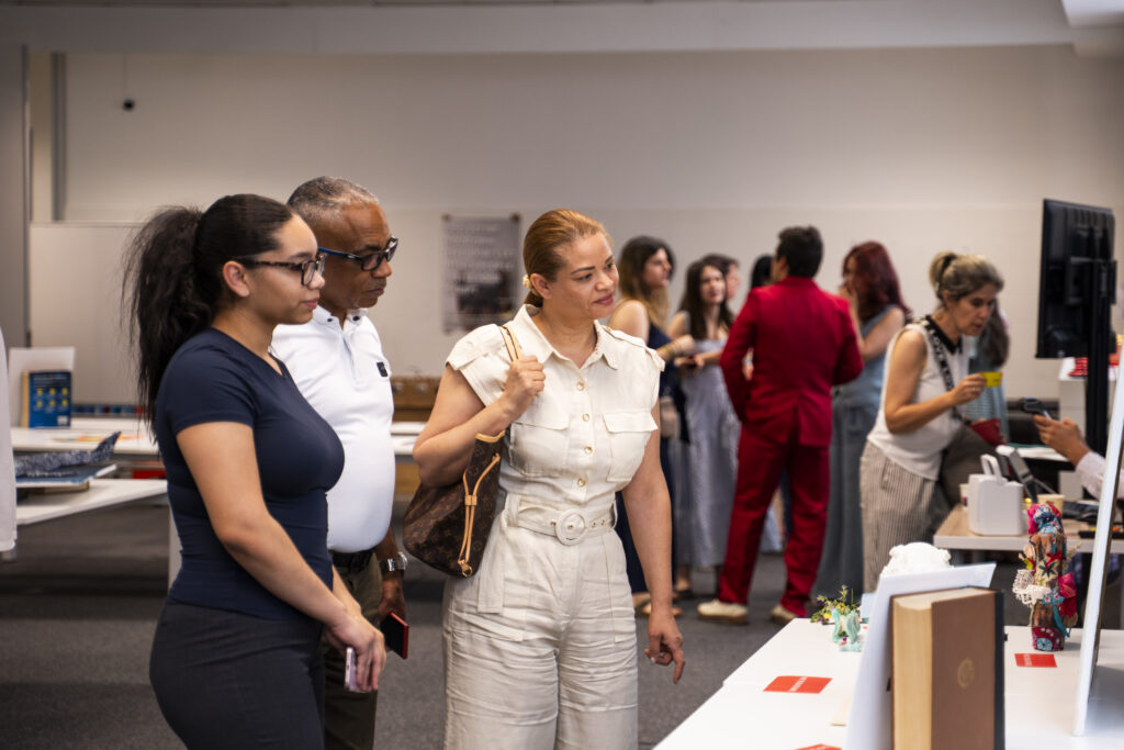 Familias y miembros de la comunidad de THP International observando las obras durante la exposición de arte solidaria